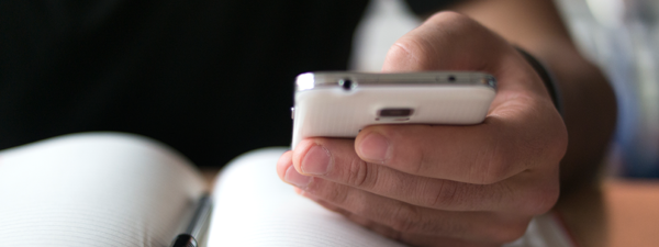 Hand holding a phone to follow-up with customer